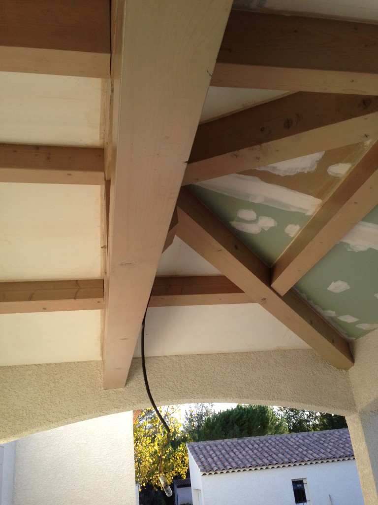 Réalisation d'un faux plafond sous le toit d'une terrasse.<br />
<br />
Les plus gros éléments de la charpente sont conservés et mis en valeur à l'aide d'une lasure grise satinée.<br />
Les faux-plafonds sont réalisés à l'aide de Placo-plâtre puis peints en blanc mat.